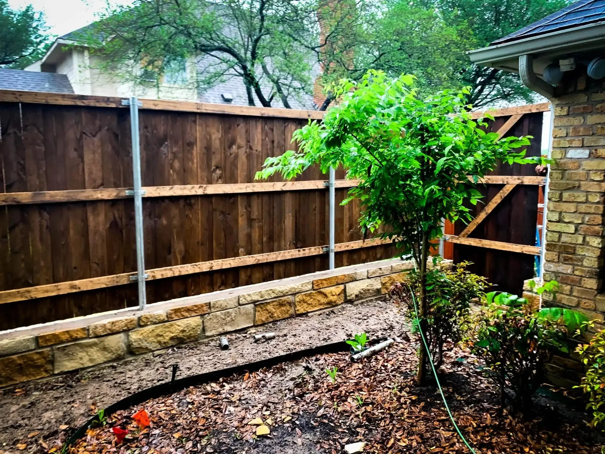 Cedar fence built on top of a stone retaining wall in DFW, photo 7