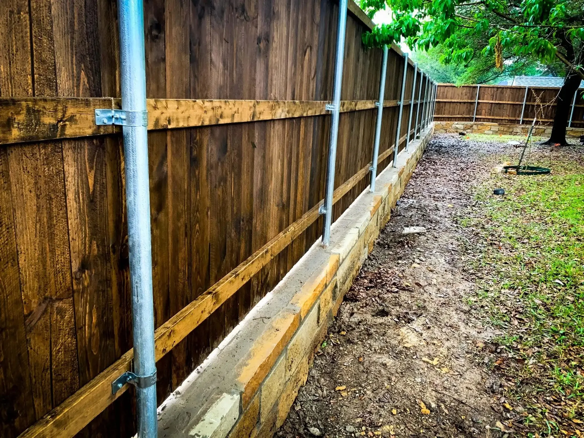 Cedar fence built on top of a stone retaining wall in DFW, photo 9