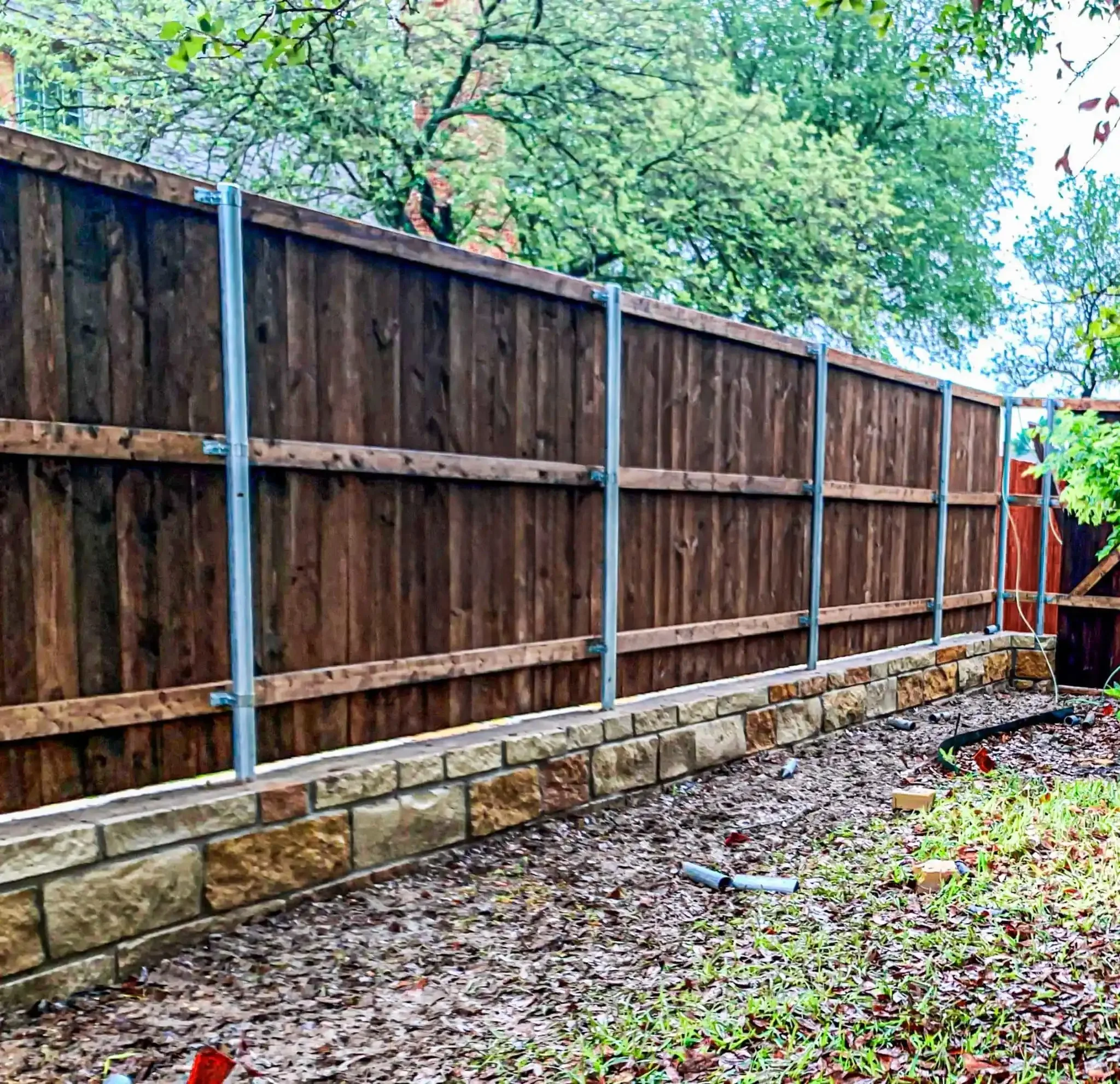 Cedar fence built on top of a stone retaining wall in DFW, photo 16