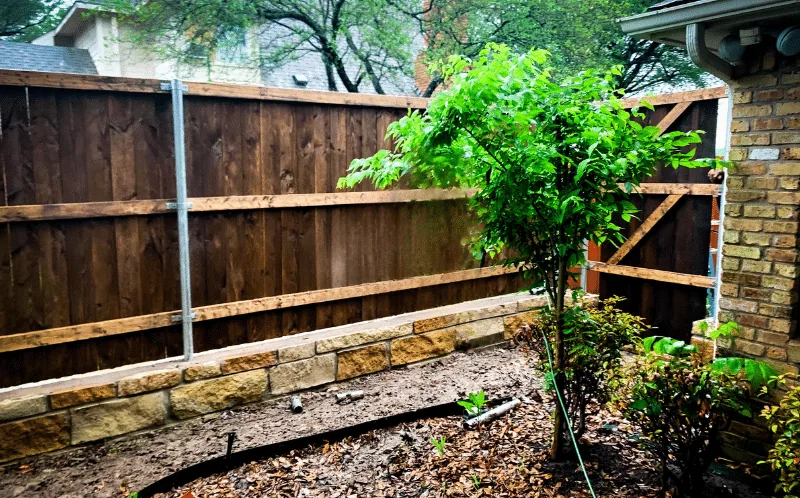 Cedar fence built on top of a stone retaining wall